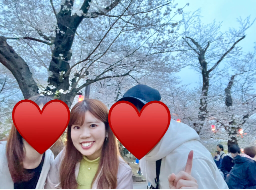 桜をバックに3人で並んで写る写真